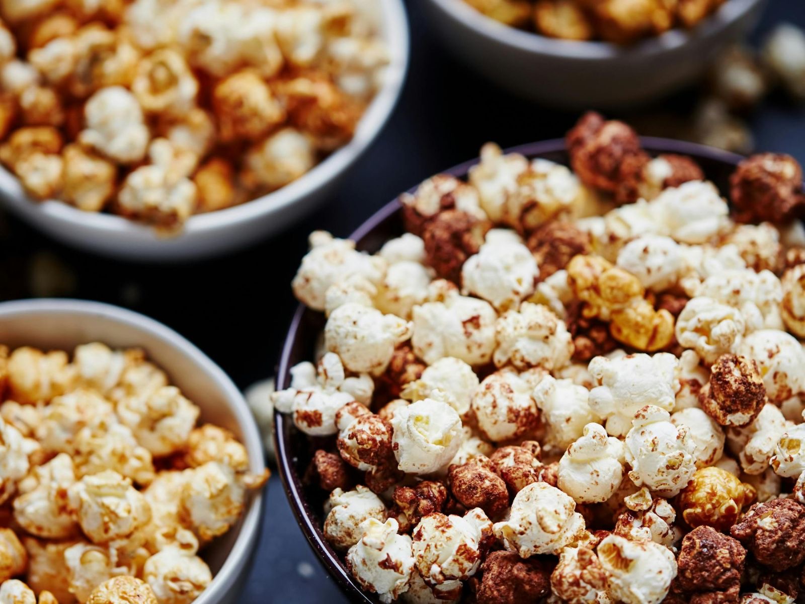 Bowls of popcorn in caramel and chocolate-drizzled varieties