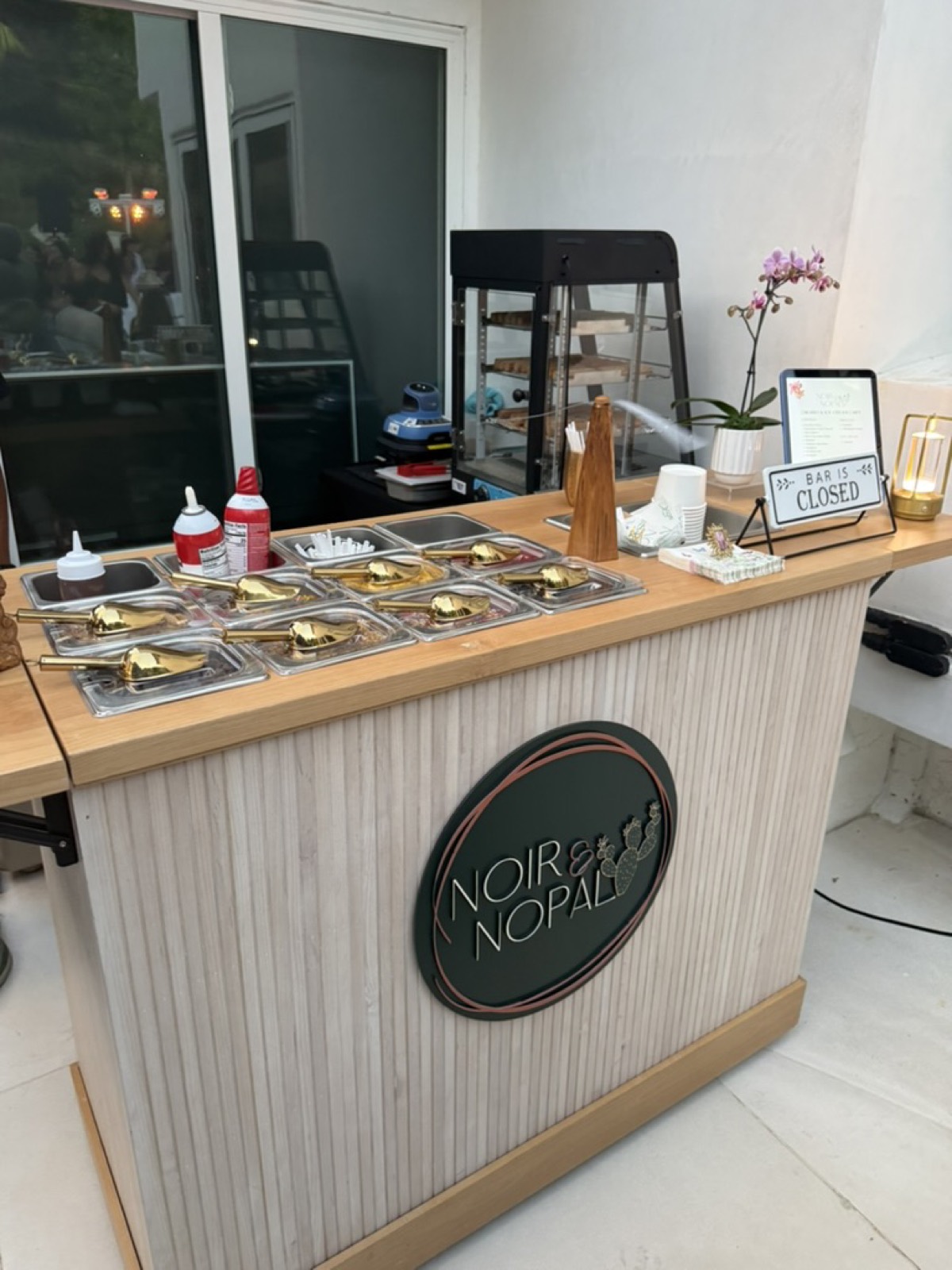 The Churro Ice Cream Sundae Cart styled and set up at a private event, with the branded Noir & Nopal sign on the front