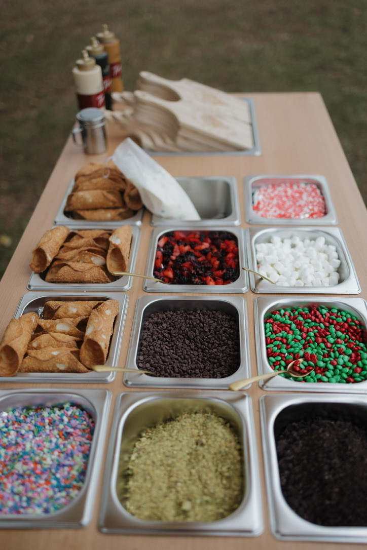 An overhead view of the topping bar, with shells, sauces, and a full row of toppings