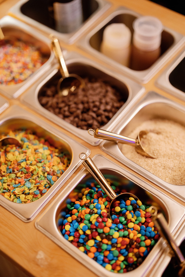 An overhead view of the topping bar, with sprinkles, chocolate chips, and cinnamon sugar